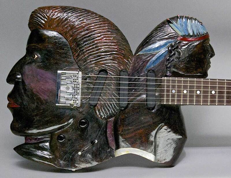 button - photo of art guitar of two faces that links to more info