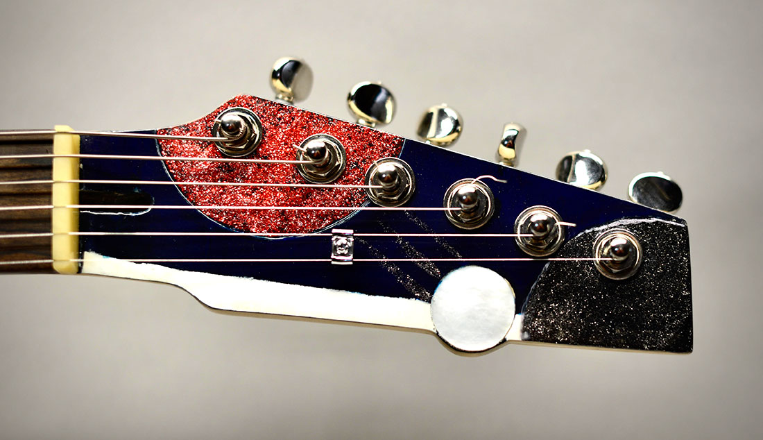 photo of headstock on guitar with ping pong theme